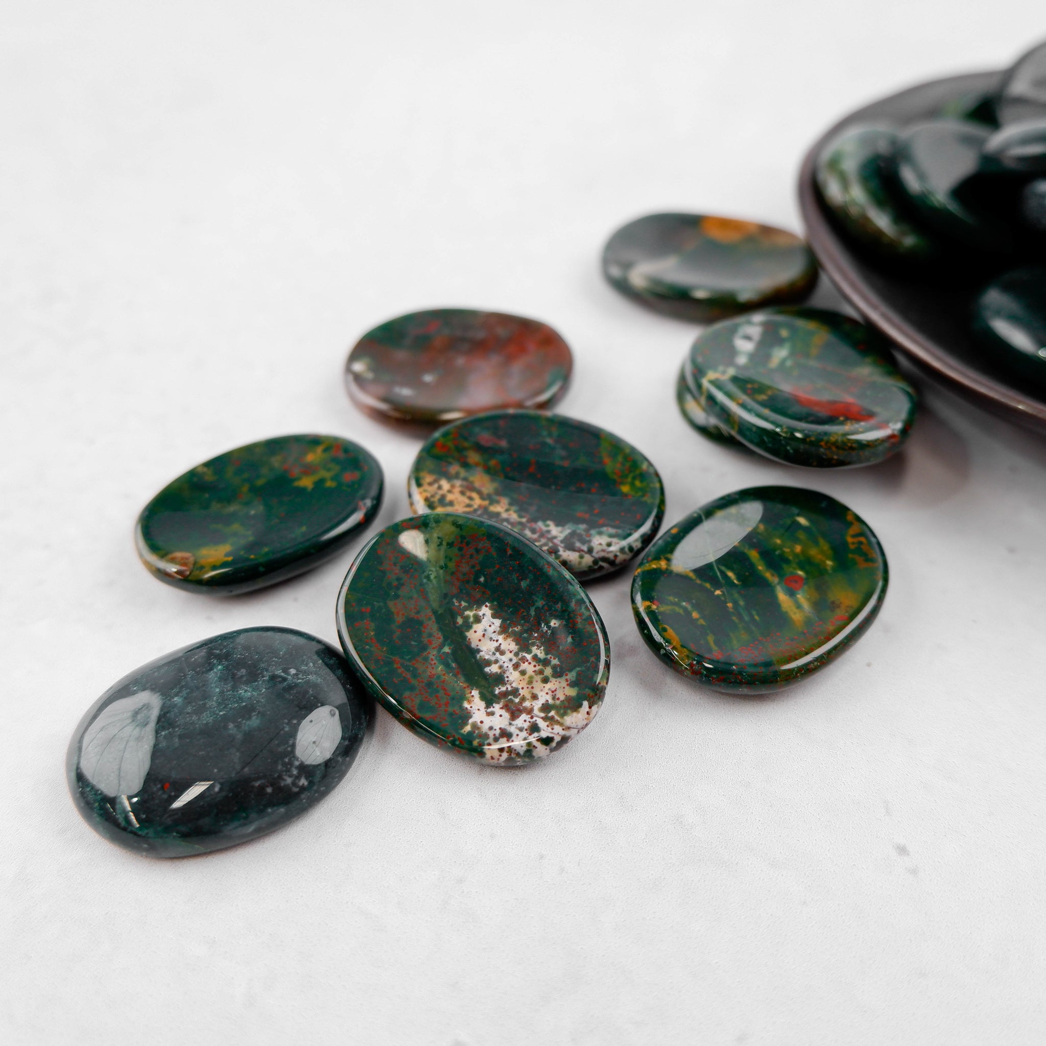 Bloodstone worry stone from Noctis Studio, smooth polished gemstone for stress relief and meditation.