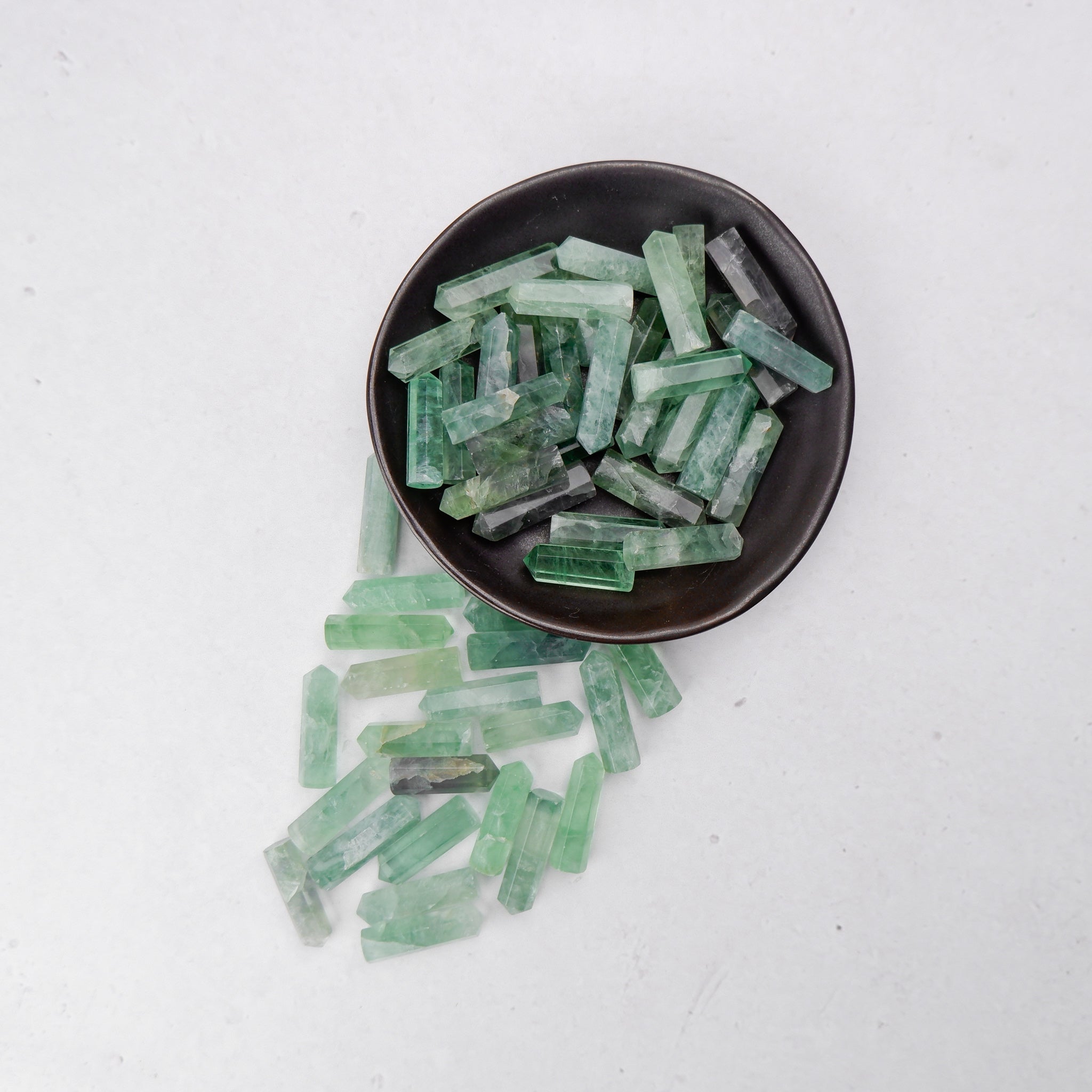 Green fluorite single gridding point from Noctis Studio with a pointed, polished crystal shape and vibrant green color.