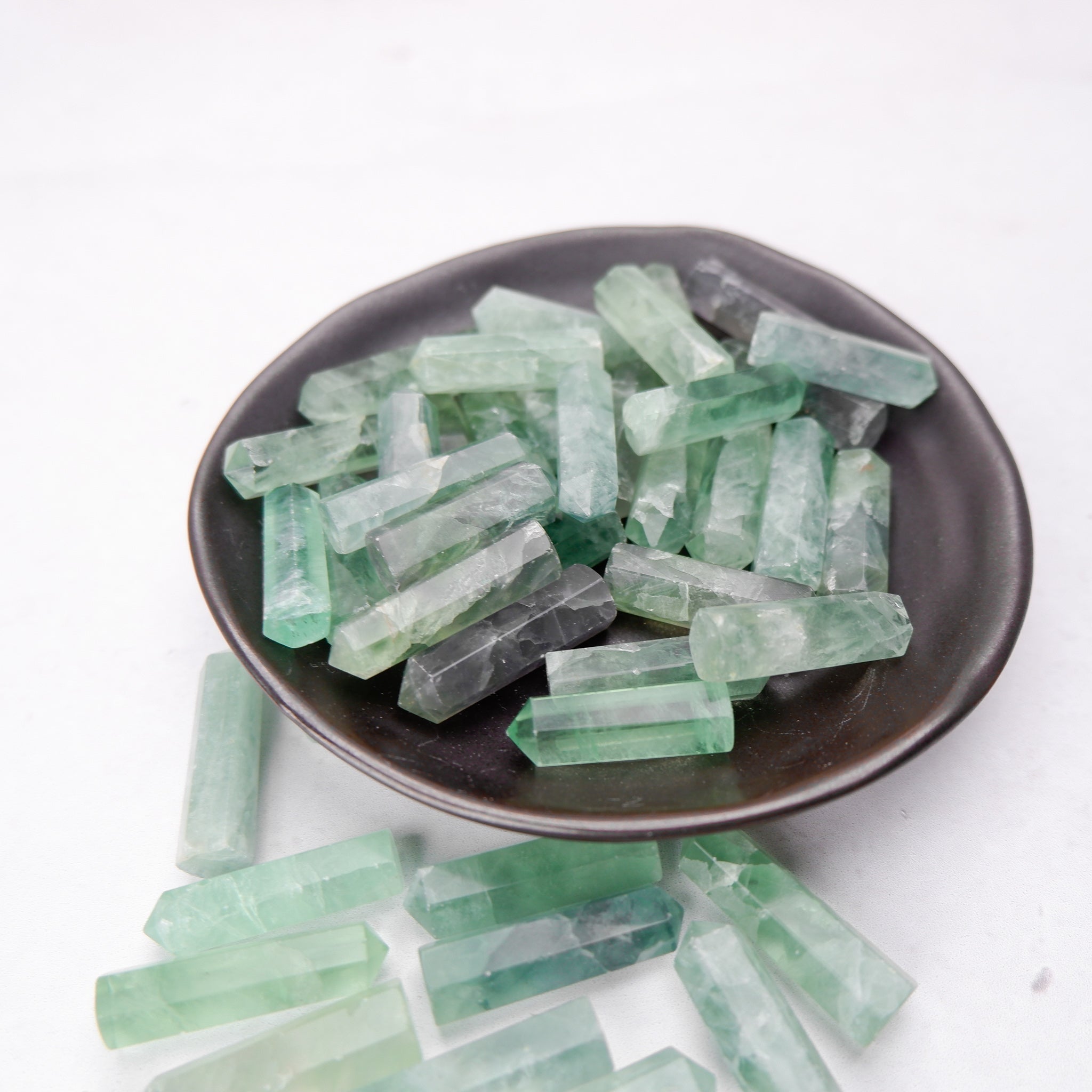 Green fluorite single gridding point from Noctis Studio, featuring a polished, pointed crystal with vibrant green hues.