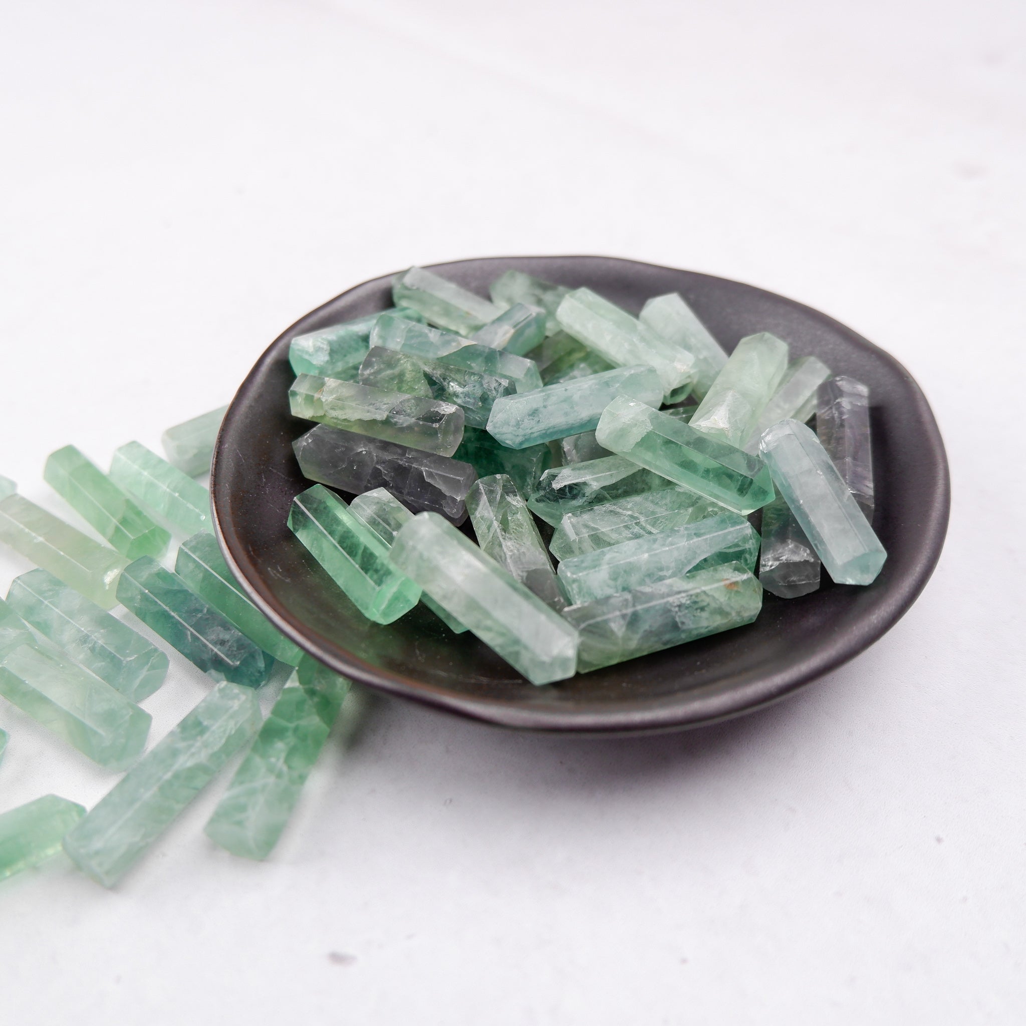 Green fluorite single gridding point by Noctis Studio, showcasing a polished mineral specimen with a pointed tip and vibrant green color.