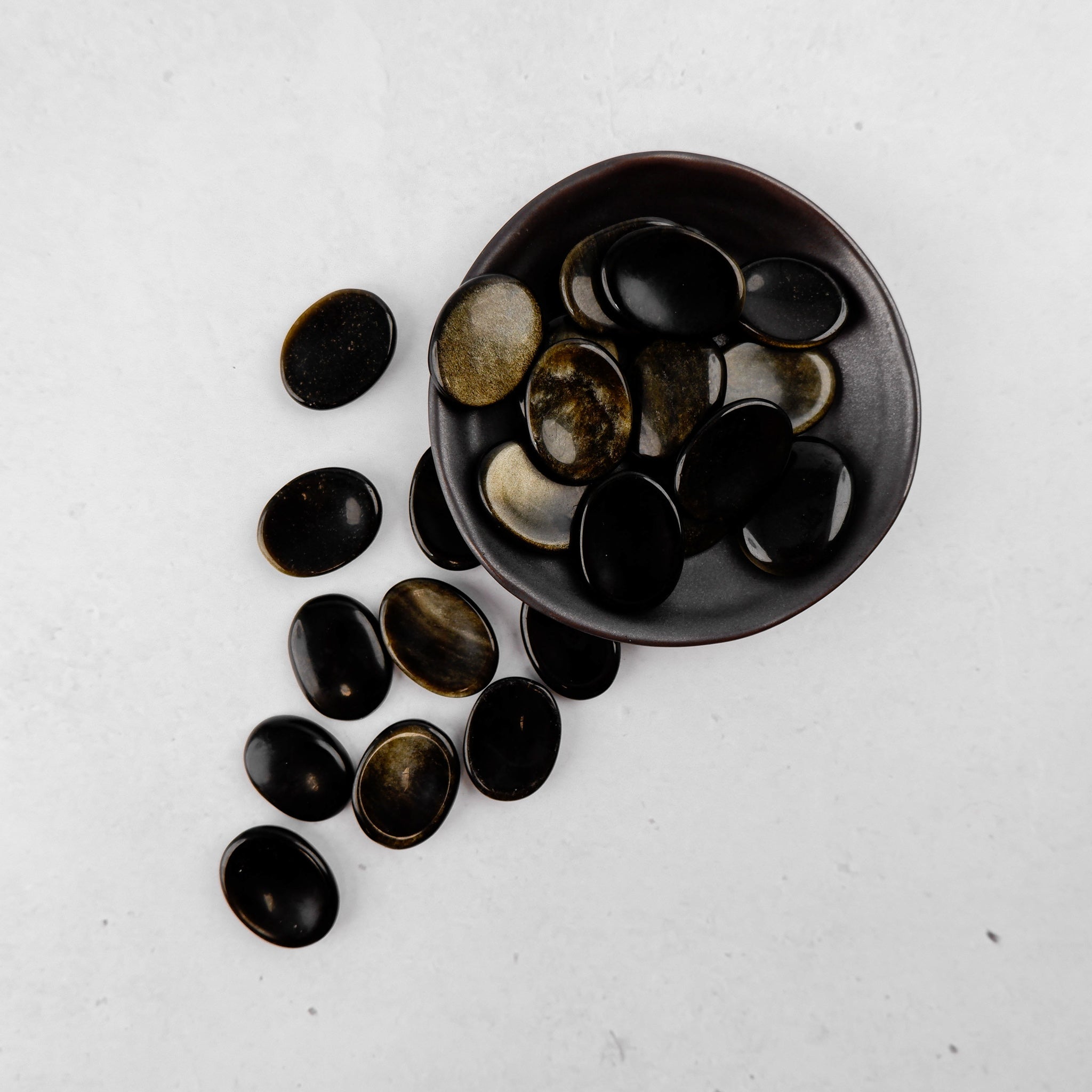 Golden Sheen Obsidian worry stone by Noctis Studio, smooth polished gemstone with a glossy, golden iridescent finish.