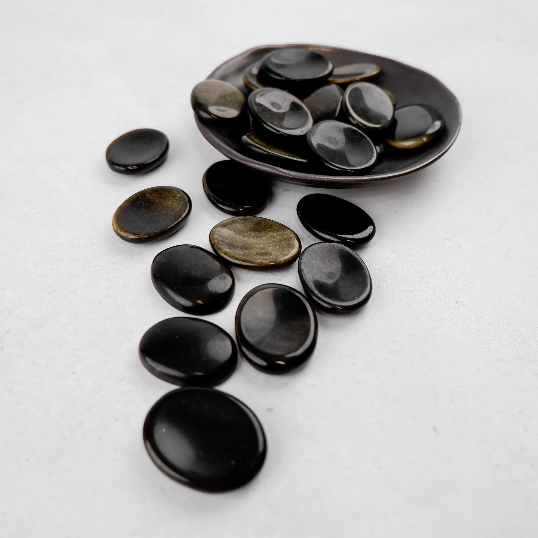 Golden Sheen Obsidian worry stone from Noctis Studio, smooth polished gemstone with a shiny golden sheen, oval shape for holding.