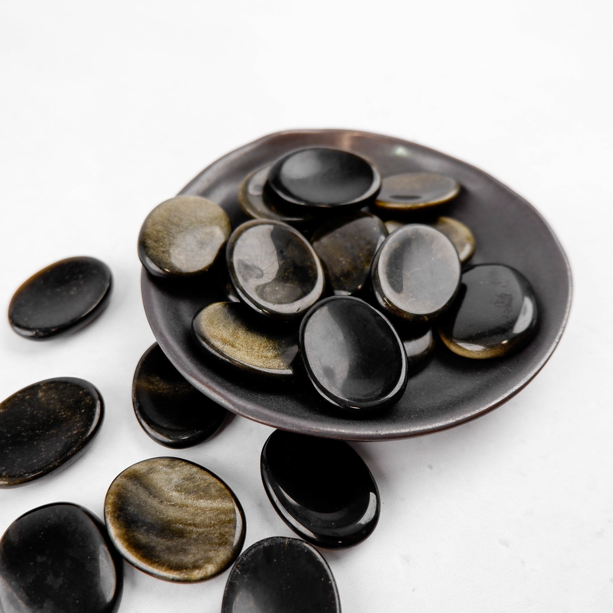 Golden Sheen Obsidian worry stone from Noctis Studio, smooth polished gemstone with iridescent golden sheen, handheld healing accessory.