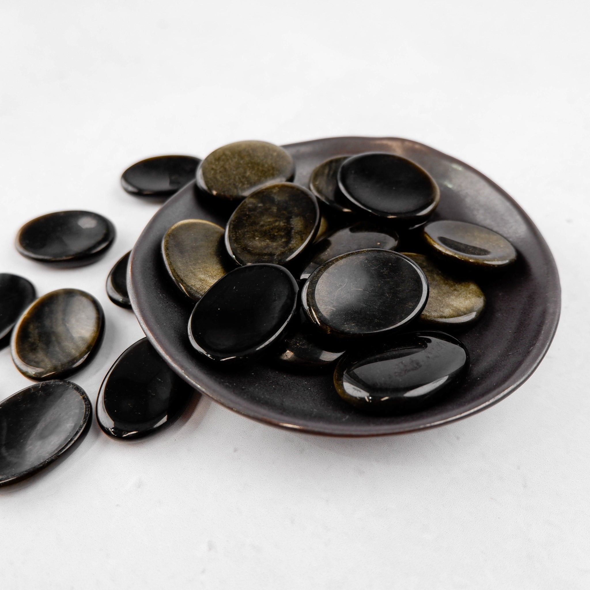 Golden sheen obsidian worry stone from Noctis Studio, smooth polished worry stone with a shimmering golden finish.