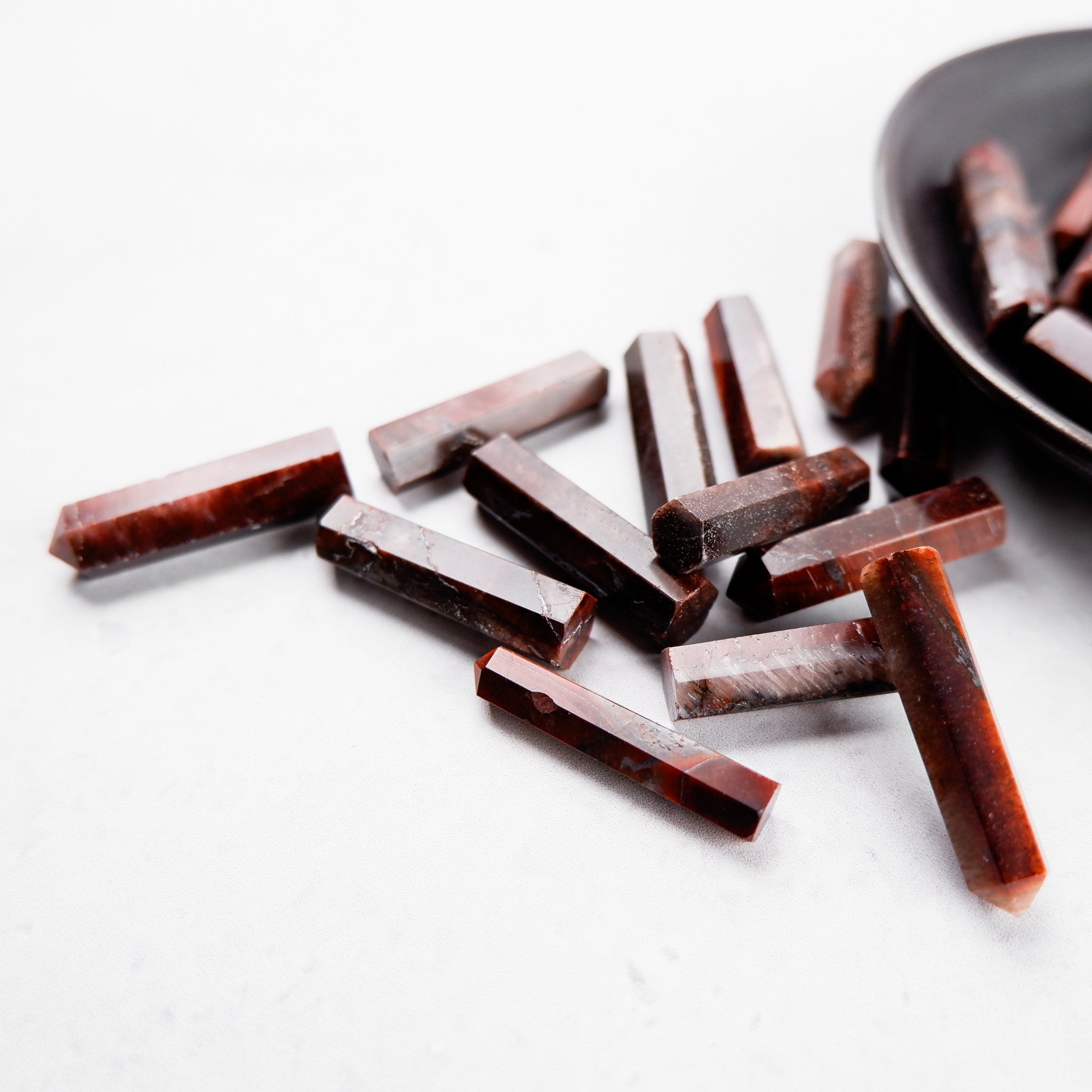 Red Tigers Eye single gridding point by Noctis Studio with a pointed tip and smooth, polished surface for jewelry making.