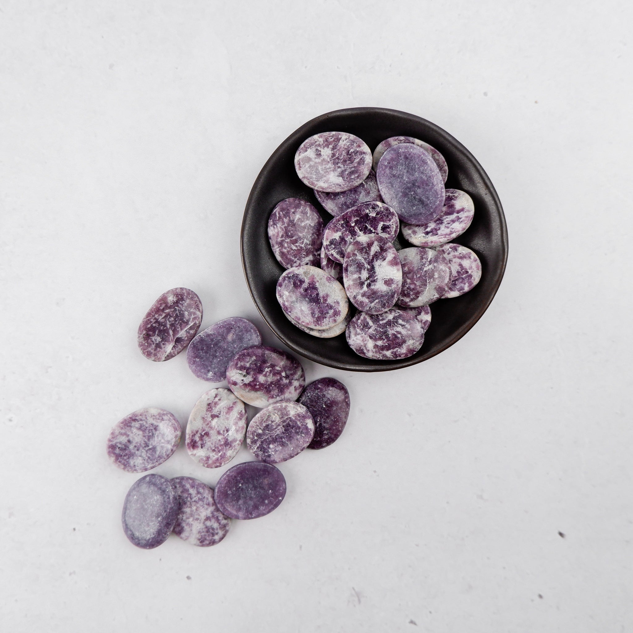 Lepidolite worry stone from Noctis Studio, smooth polished gemstone for stress relief and calming touch.