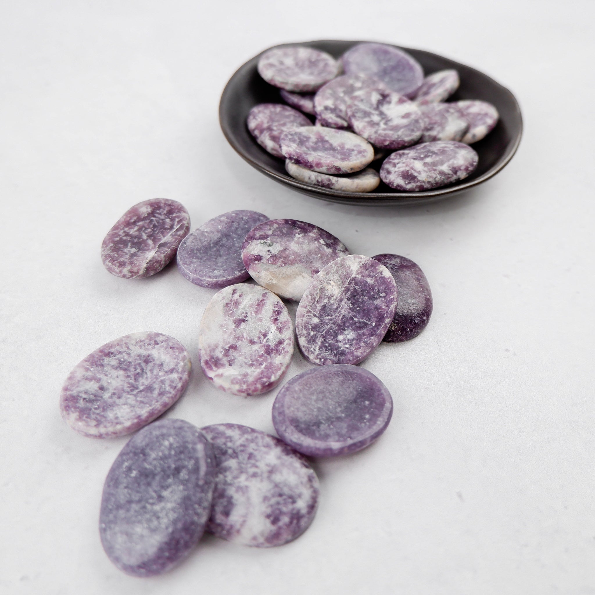 Lepidolite worry stone from Noctis Studio, smooth polished gemstone for stress relief and calming meditation.