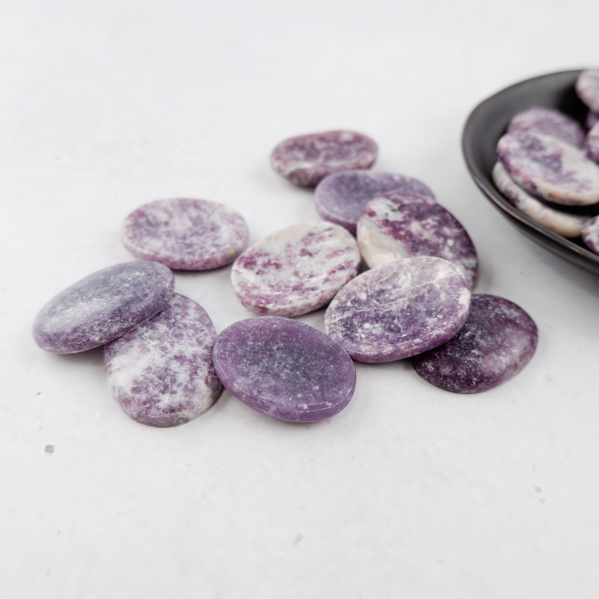 Lepidolite worry stone from Noctis Studio showcasing smooth, polished purple mineral with calming energy for stress relief.