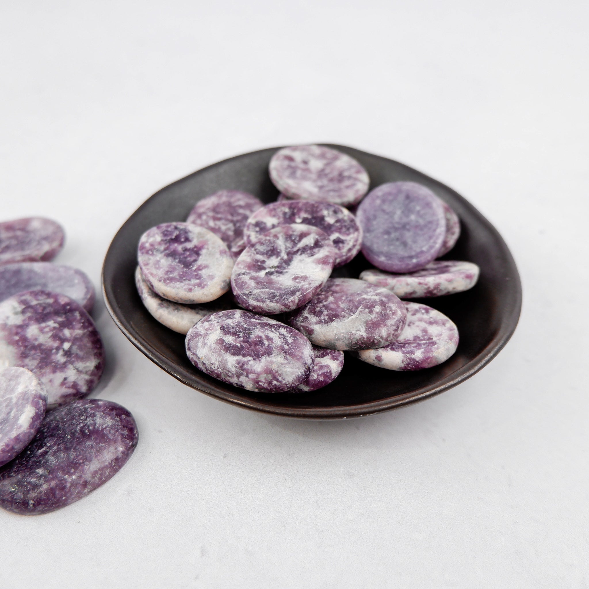 Lepidolite worry stone from Noctis Studio, smooth polished gemstone for stress relief and meditation.