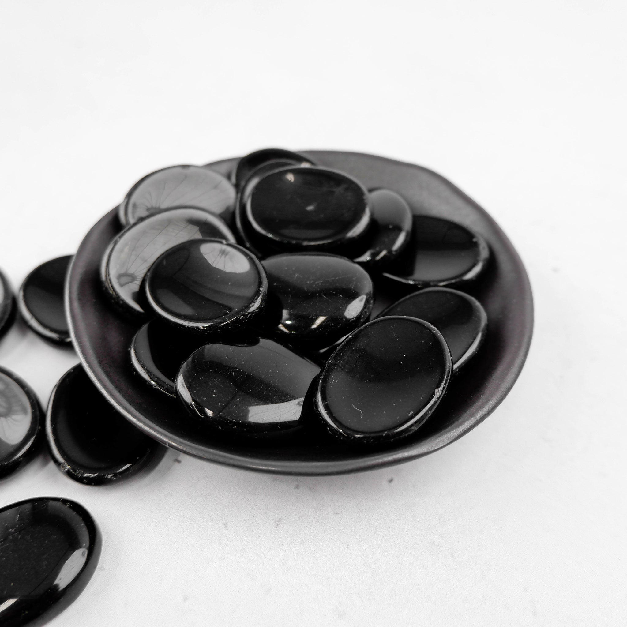 Obsidian worry stone from Noctis Studio, smooth black polished gemstone for calming meditation and stress relief.