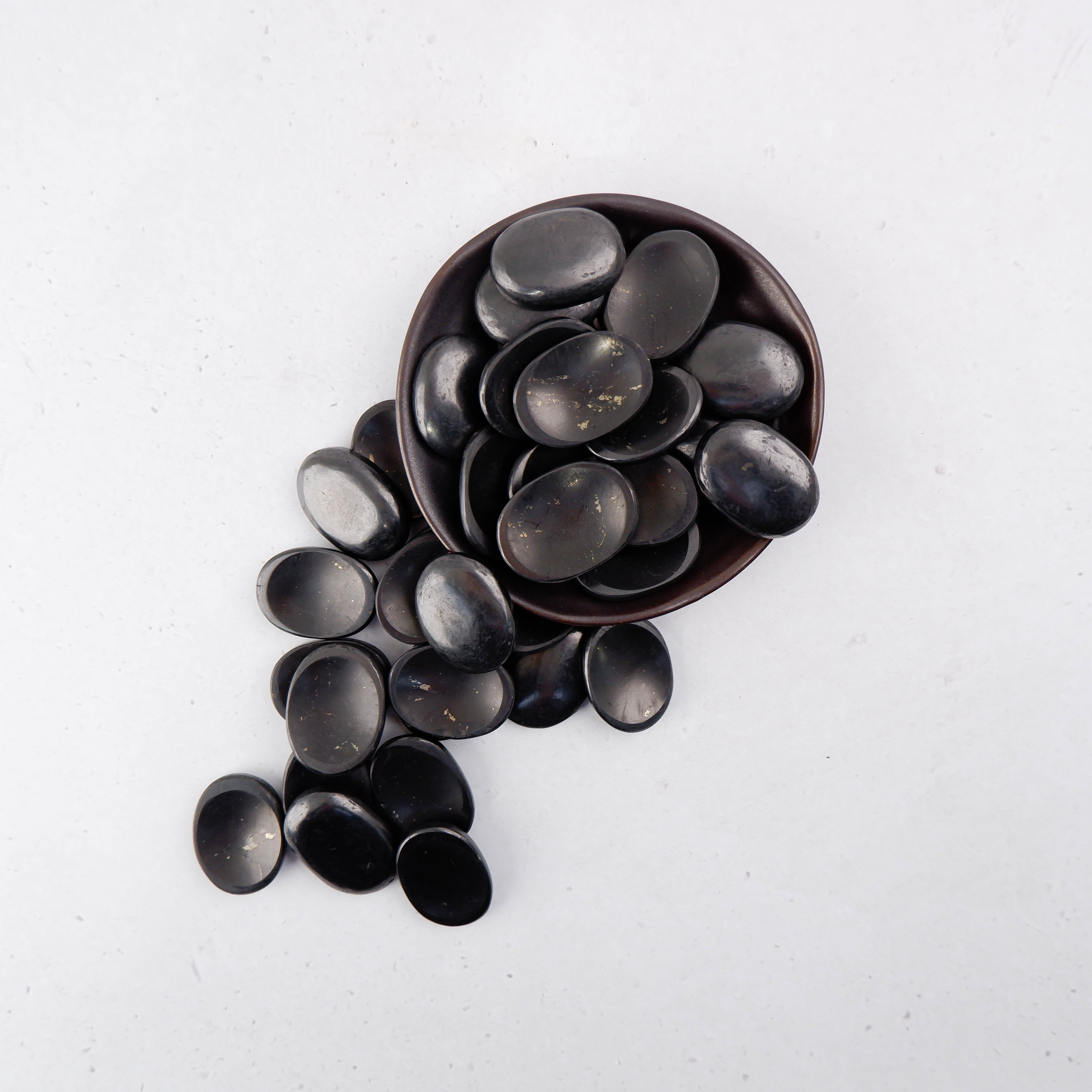 Shungite worry stone by Noctis Studio, smooth black gemstone with polished surface for stress relief and meditation.