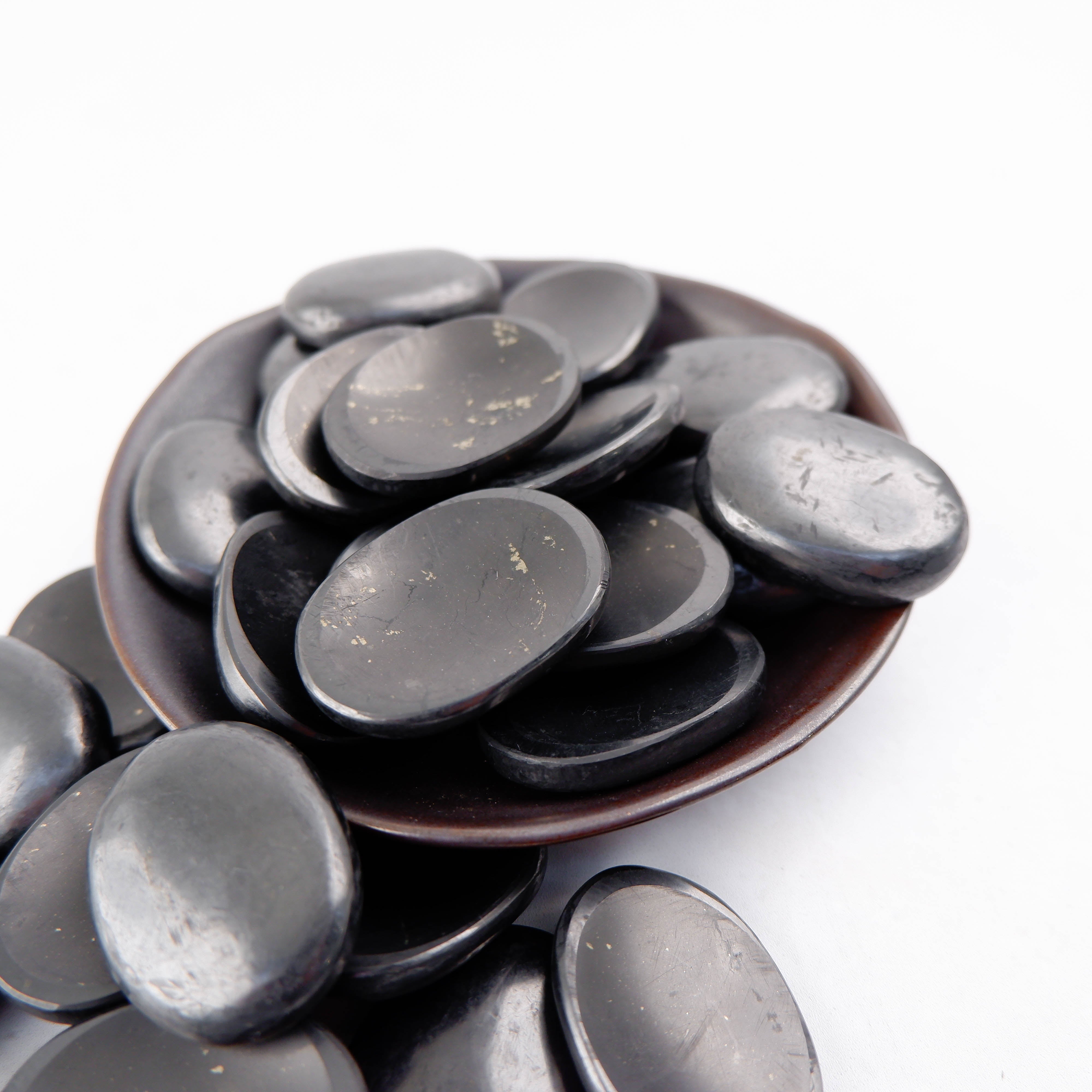 Shungite worry stone from Noctis Studio, smooth black gemstone used for stress relief and meditation.