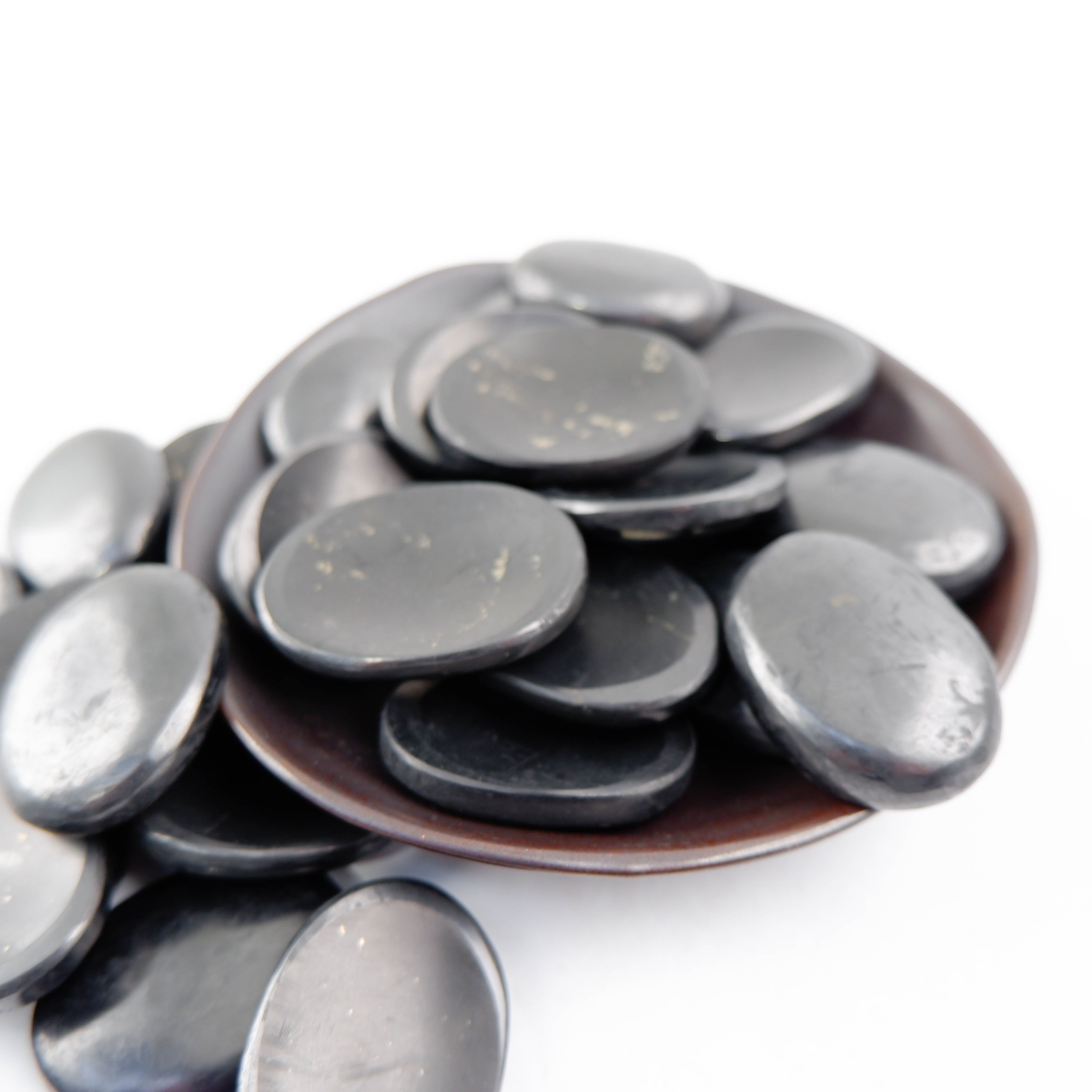 Shungite worry stone from Noctis Studio showing a smooth, polished black gemstone with natural texture and oval shape.
