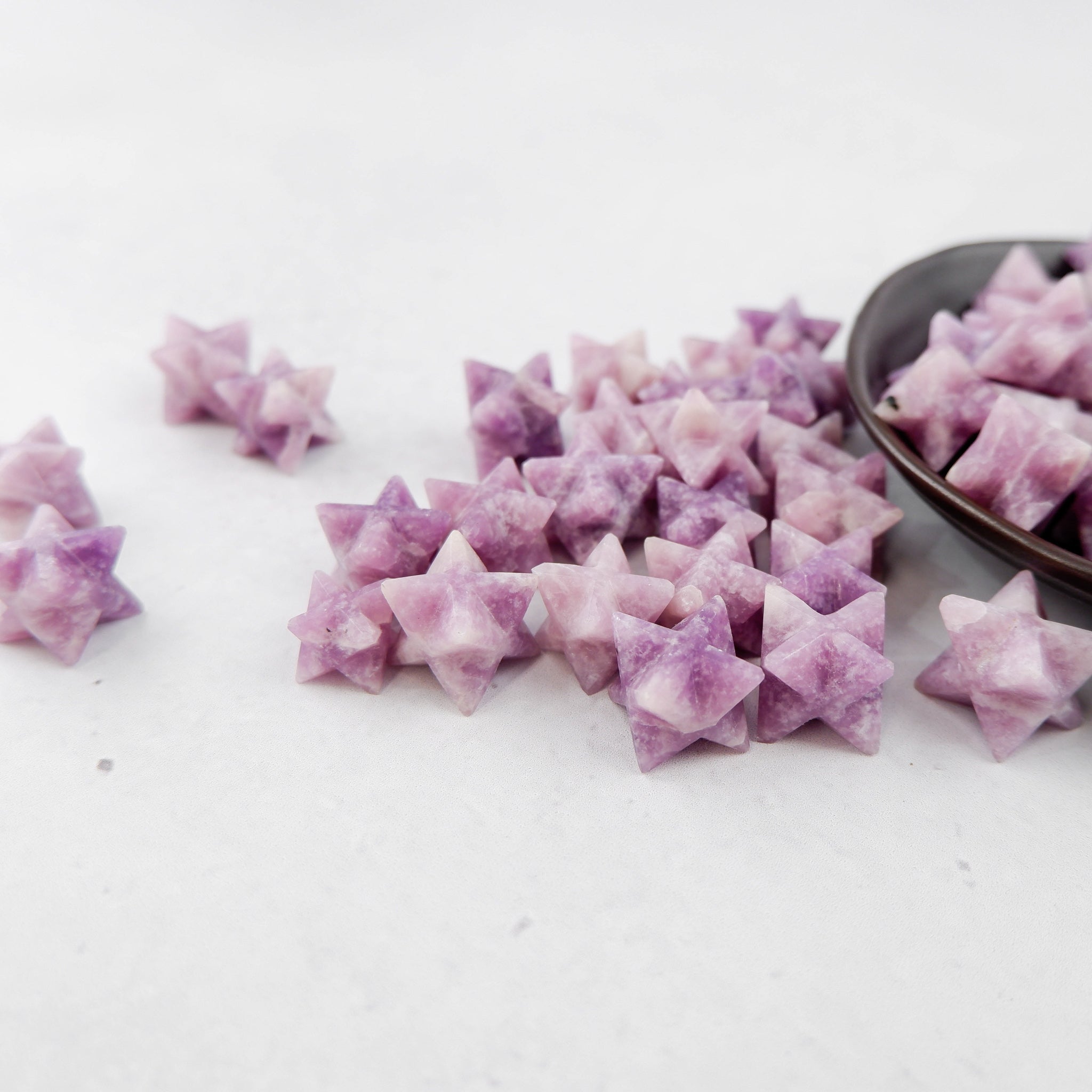 Lepidolite star gemstone from Noctis Studio, polished star-shaped mineral with purple and lilac hues on a white background.