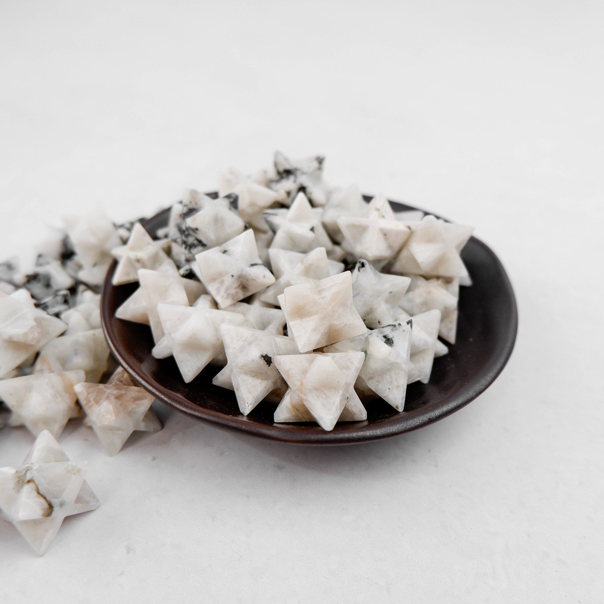 Shiny moonstone star pendant from Noctis Studio with a smooth, polished surface and vibrant blue and white hues.