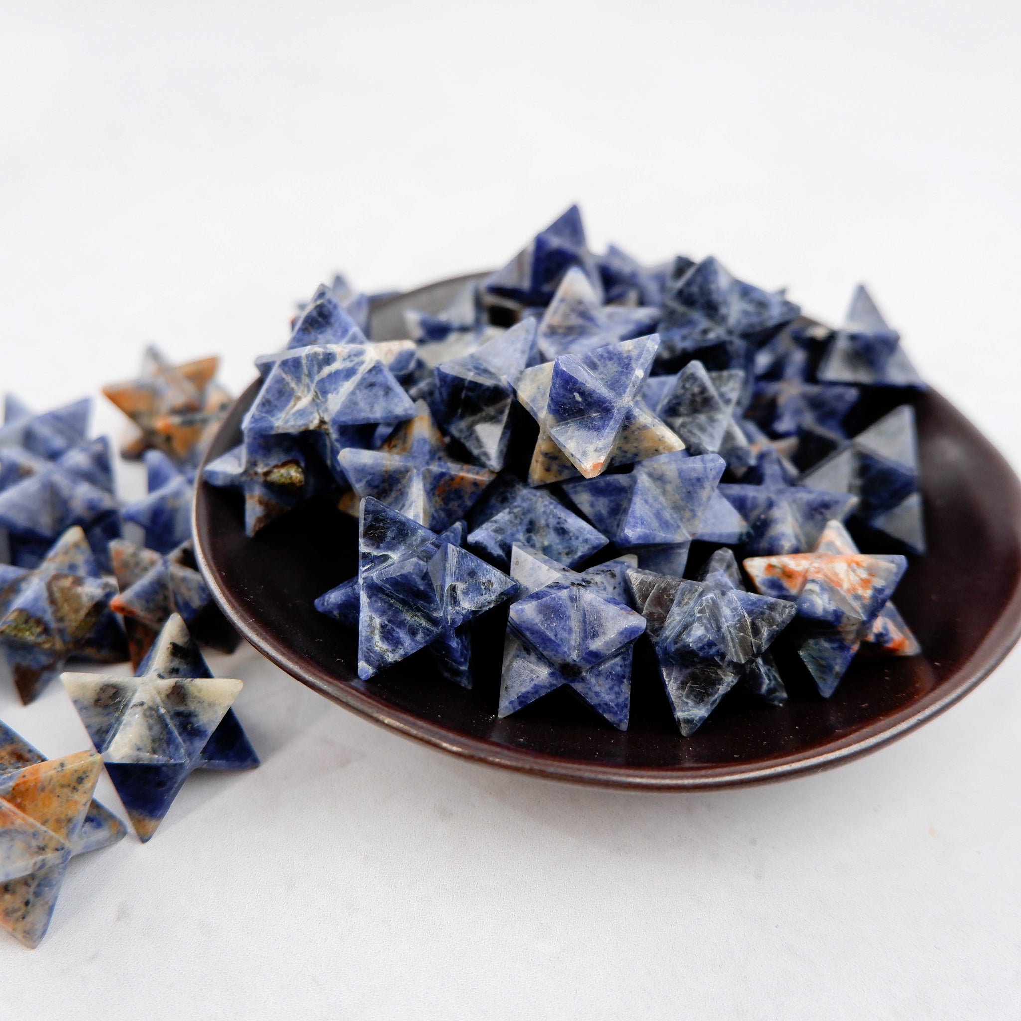 Sodalite star gemstone sculpture by Noctis Studio, polished blue stone with natural veining and a star shape on a plain background.