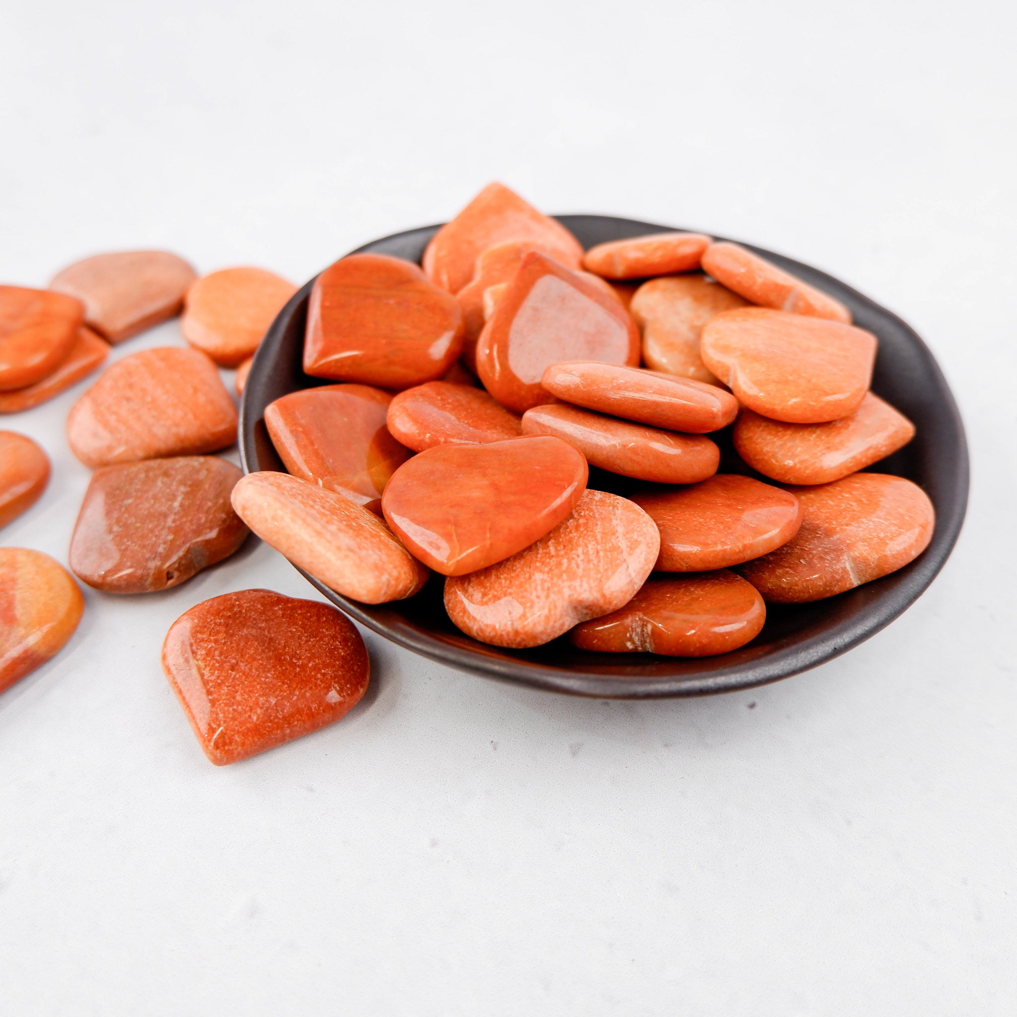 Pink peach aventurine heart gemstone from Noctis Studio, polished and smooth, showcasing its warm, translucent appearance.