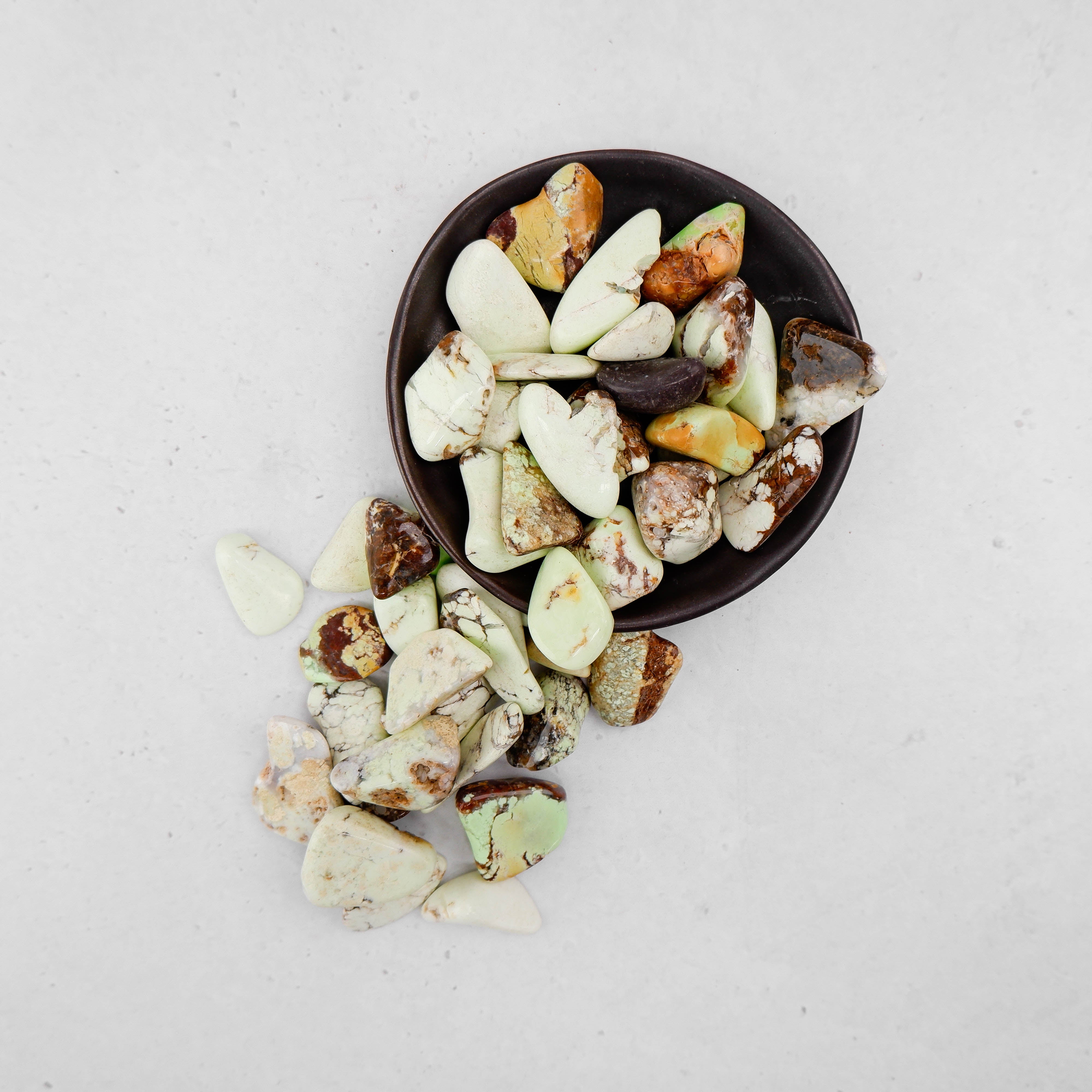 Lemon chrysoprase tumble stone by Noctis Studio, smooth polished gemstone with vibrant yellow-green color and natural inclusions.