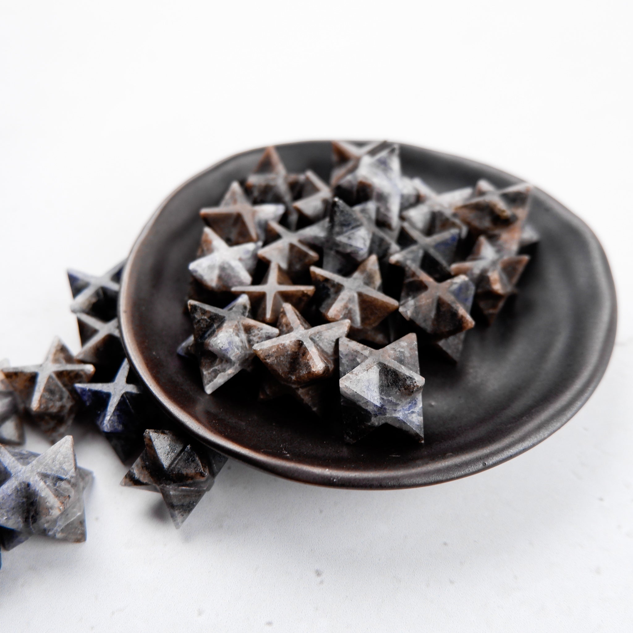 Iolite Star gemstone from Noctis Studio, showcasing a polished star-shaped Iolite with vibrant blue hues and smooth surface.