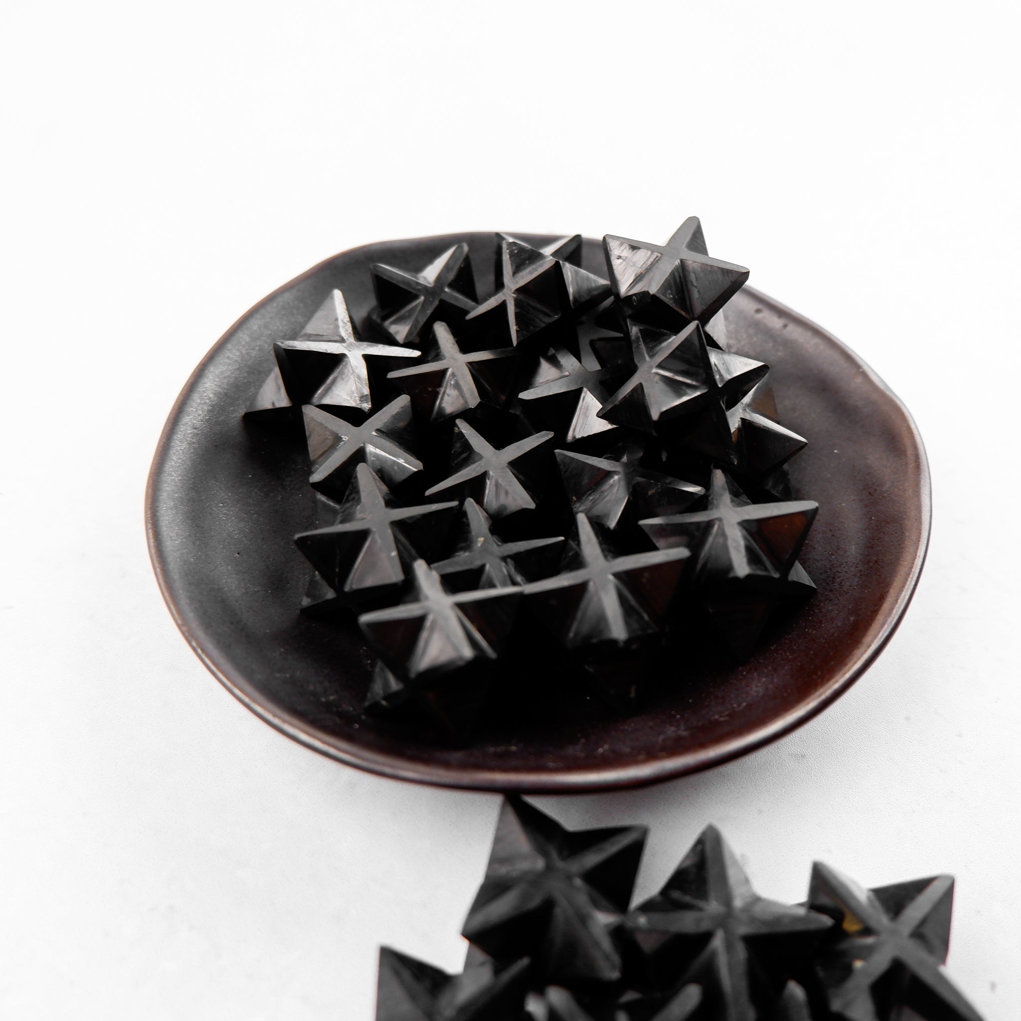 Shungite star-shaped mineral from Noctis Studio, showcasing a polished black stone with natural patterns and star shape details.