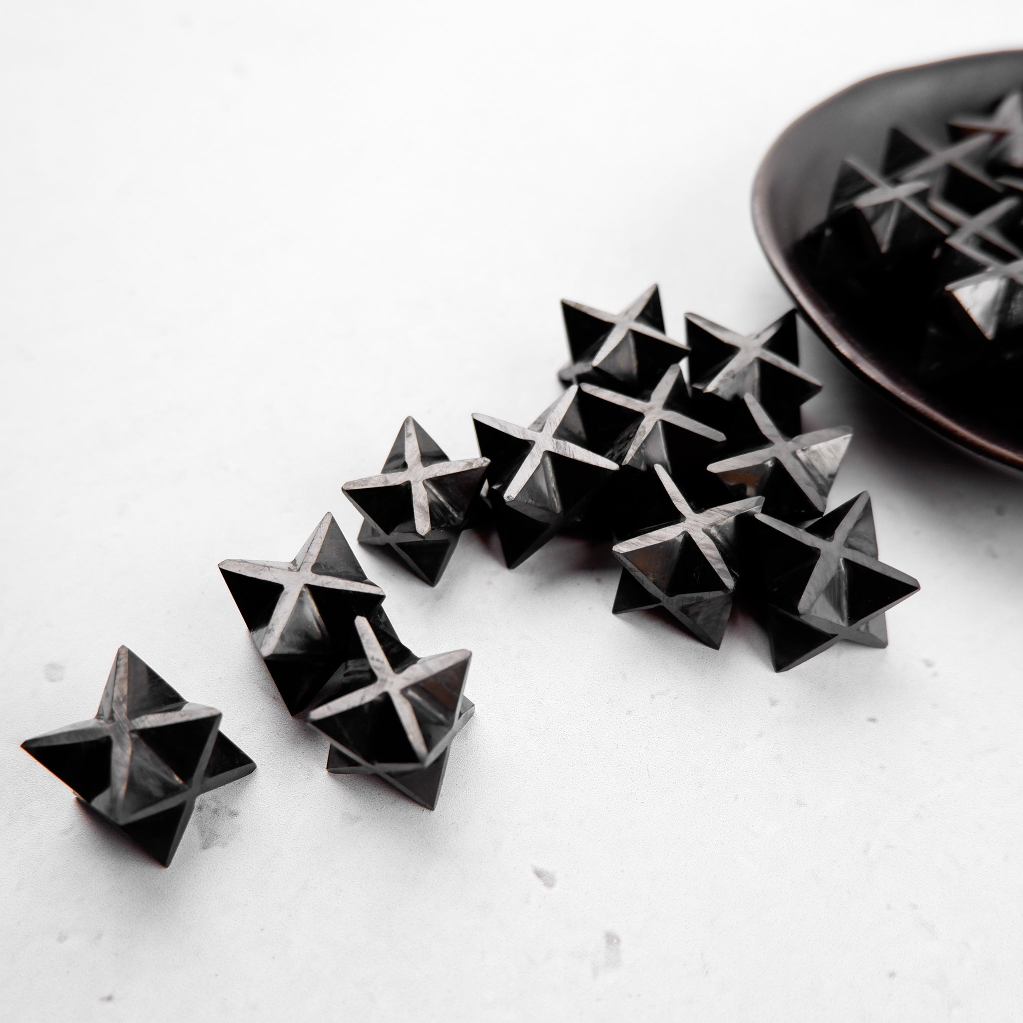 Noctis Studio Shungite star sculpture with a smooth, polished black surface and star shape, displayed on a neutral background.