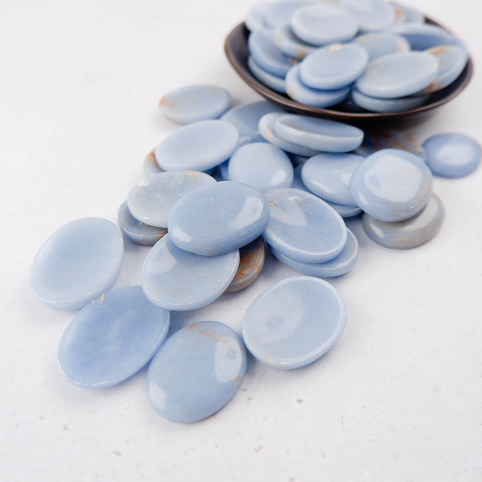 Smooth angelite worry stone by Noctis Studio, showcasing its calming blue-gray color and polished, rounded surface.