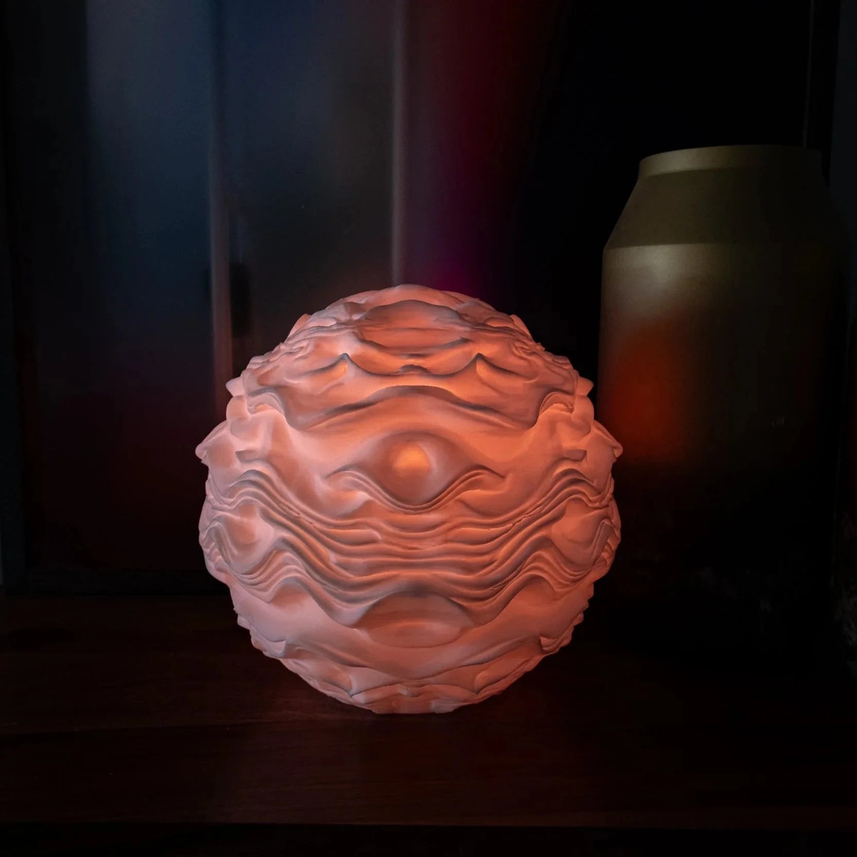 Noctis Studio Syzygy Lamp emitting a soft, warm glow with a modern, sculptural design perfect for ambient lighting in living spaces.